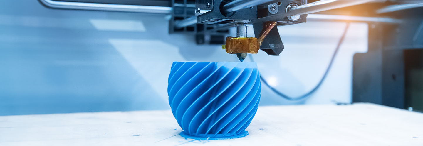 Ein Kunstoffwerkstück wird in Detailaufnahme von einer 3D-Druckmaschine Stück für Stück aufgebaut